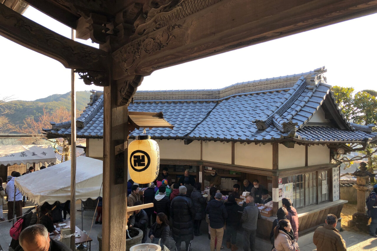 特急やくおうじ号2027|正月の運転日・時刻・停車駅と薬王寺への行き方 2 正月の薬王寺境内で授与所周辺に集まる多くの参拝者と提灯